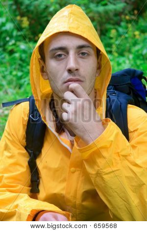 Backpacker in a yellow coat resting