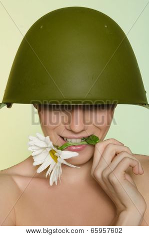 Woman In A Military Helmet Bites Chamomile