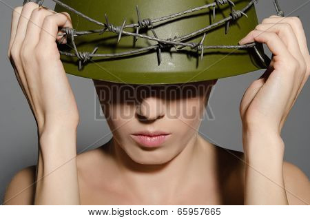 Woman Holding Hands Military Helmet With Barbed Wire