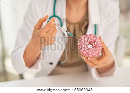 Closeup On Medical Doctor Woman Making Injection Using Diabetes Syringe Into Donut