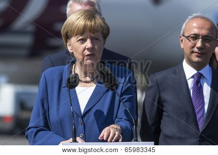 BERLIN, GERMANY - MAY 20, 2014: German Chancellor Angela Merkel (L), Turkish Minister of transport Lutfi Elvan (R) open up the International aviation and space exhibition ILA.