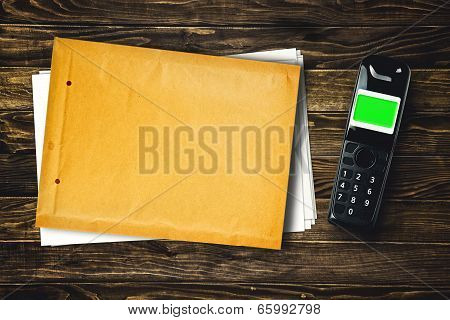 Wireless Phone And Blank Envelope On Tabletop
