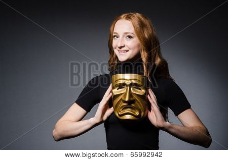 Redhead woman iwith mask in hypocrisy consept against grey background