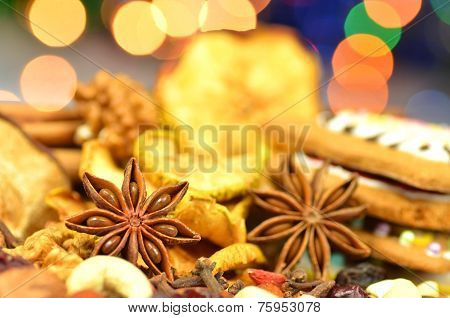 christmas spices, nuts, cookies and dried fruits on bokeh background