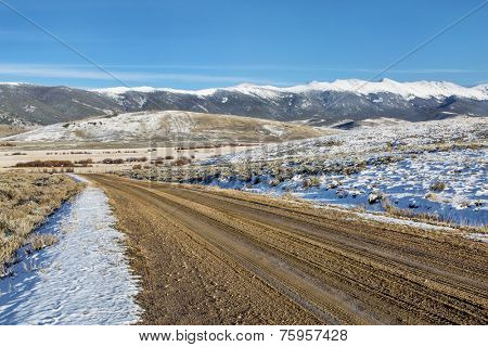 dirt backcountry road with  snowy Medicine Bow Mountains in background, North Park near Walden, Colorado, late fall scenery