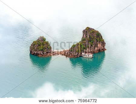 Vietnam Halong Bay cruise boat near tropical island. Aerial photo view of mountain in sea near Hanoi - adventure travel landscape background  
