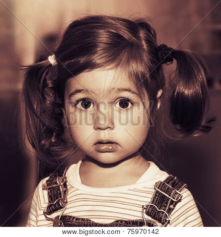 Portrait of cute sad little girl thinking. Toned