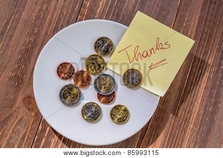 a plate of coins for tips or fee for toilets. in english