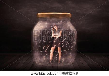 Businesswoman locked into a jar with question marks concept on background