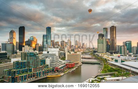 Melbourne, Australia - January 31, 2017: View of Melbourne skyline and Yarra River at sunrise with hot air balloons in the sky