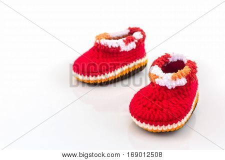 Little baby shoes. Kids knitted shoe handicraft on white background.