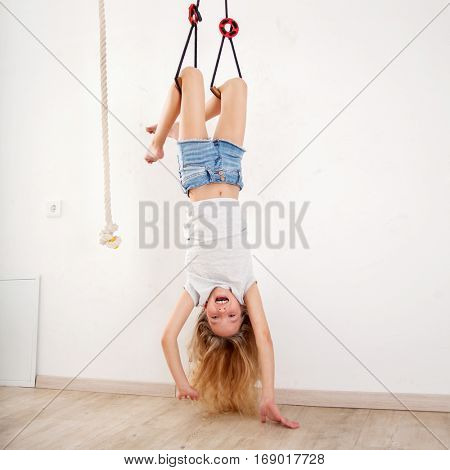 Girl on the wall bars. Child at wall bars do sport exercises