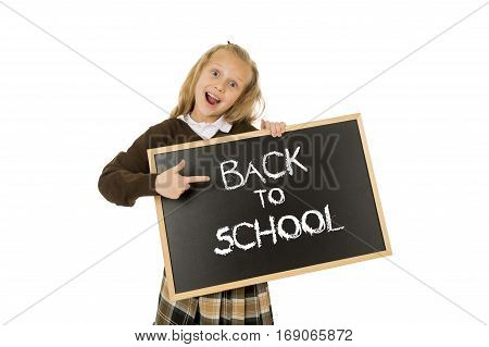 7 8 years old little beautiful blond schoolgirl smiling happy and cheerful holding and showing small blackboard with text back to school in end of holidays and education concept isolated white