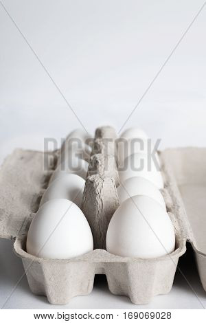 ten white egg in paper box- isolated on white background