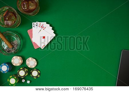 Set to playing poker with cards and chips on green table. View from above with copy space. Banner template layout mockup for online casino. Green table, top view on workplace.