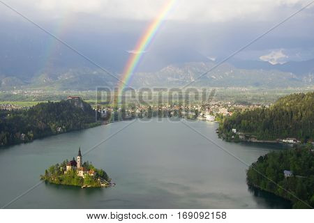 View of Lake Bled from Little Osojnica Hill, at sunny day after rain with rainbow on background, Slovenia