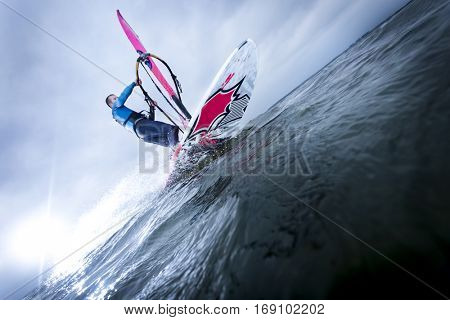 carving of a windsurfer at an open lake