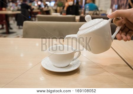 Teapot and cups are prepared for tea drinking in cafe