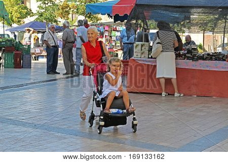 Besalu Spain - September 09 2014: Grandmother walking with baby girl in street of Besalu in Spain