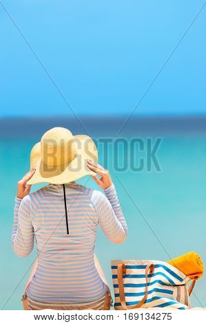 young woman in rashguard enjoying summer vacation at perfect caribbean beach with turquoise water sun protection concept