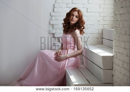 Redhead girl in pink dress on white background