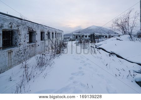 Abandoned prison settlement with decayed buildings in Kolyma winter view