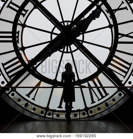 Woman Silhouette Standing In Front Of Large Clock