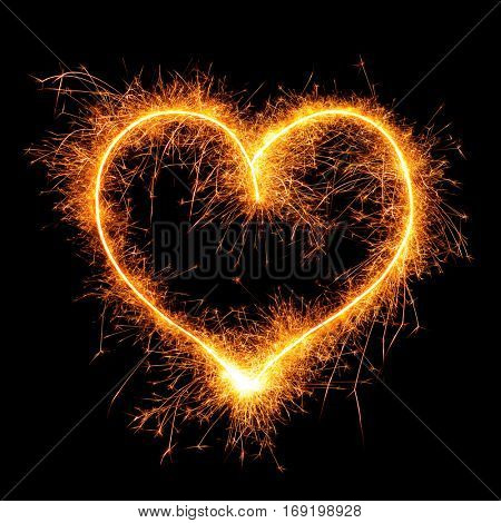 Heart from sparkler on black background. Design element for wedding or Saint Valentine card. Love symbol Valentine's Day from bengal fire - using camera with slow shutter speed. 