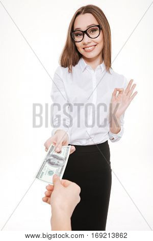 Smiling business woman accepting money offering or bribe isolated on white