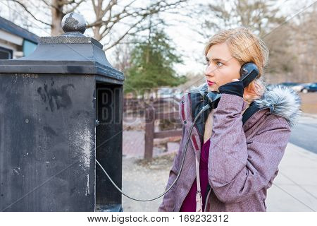 Young woman calling in phonebooth in winter