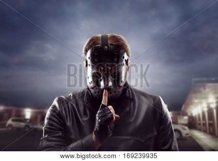 Bloody maniac in hockey mask show do not talk sign