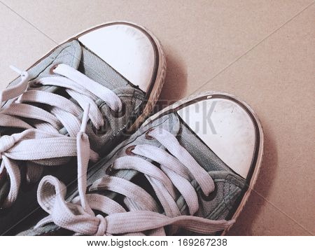 Dirty shoes top view of blue sneakers display on brown background. Vintage effect.