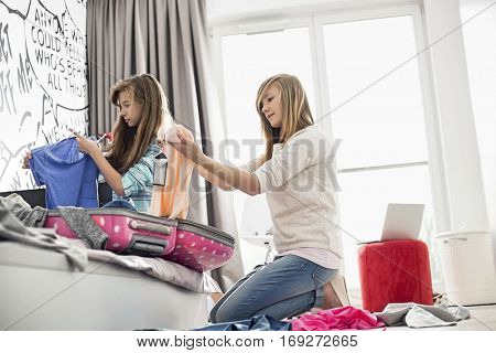 Sisters cleaning bedroom
