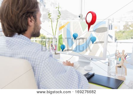 Desinger working on his computer against red drawing pin