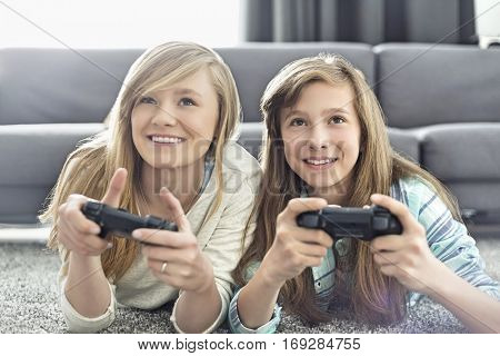 Sisters playing video games in living room