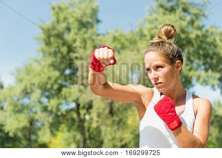 Hook punch on tae bo training, toned image, outdoors
