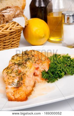Salmon with shrimps and greens on a white plate