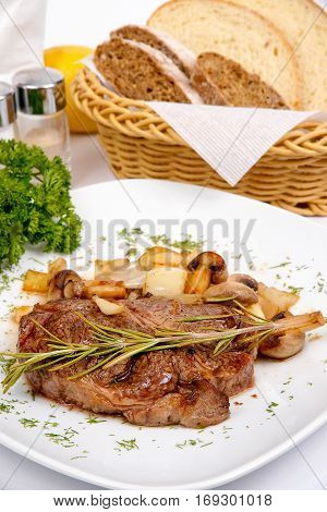 pork steak with mushroom hunting and rosemary on a white plate with spices