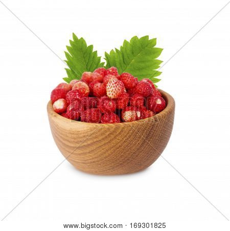 Wild small strawberries in a wooden bowl with leaves. Ripe and tasty strawberries isolated on white background. Sweet and juicy berry with copy space for text.