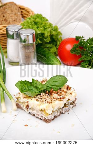 Layered salad of meat with herbs and nuts on a white plate