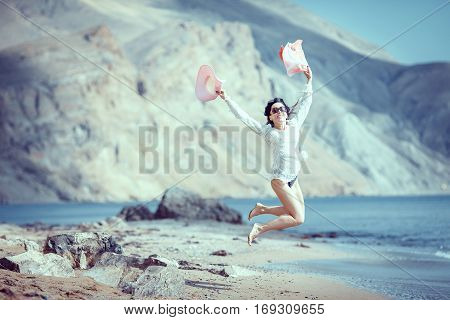 Happy woman enjoying beach relaxing joyful in summer by tropical blue water.