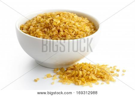 Dry Bulgur Wheat In White Ceramic Bowl Isolated On White. Spilled Bulgur.