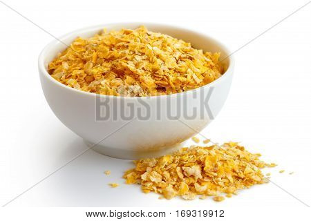 Dry Flaked Corn In White Ceramic Bowl Isolated On White. Spiled Flakes