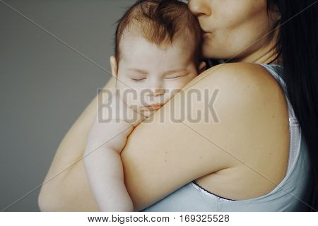 little baby asleep in the arms of his mother. cute child, happy mother