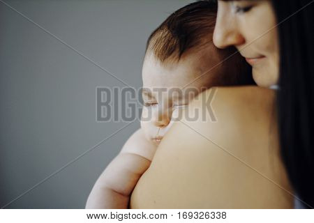 little baby asleep in the arms of his mother. cute child, happy mother