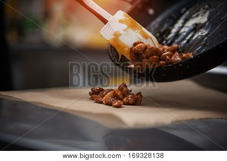 Almond caramel cooking. Preparing nuts on pan with sugar for dessert