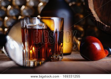 Glass of whiskey, magnifying glass and smooking pipe