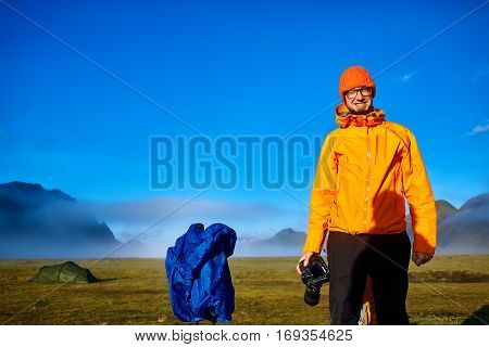 man hiker photographer taking picture on the mountain lake background in Iceland