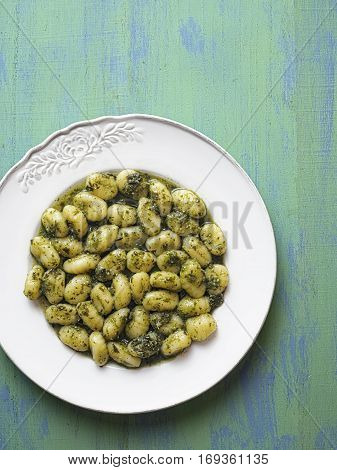 close up of rustic italian gnocchi in pesto sauce
