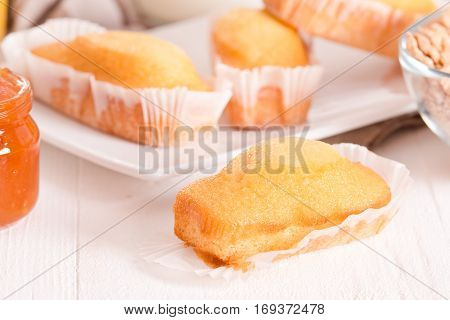 Breakfast with plumcake and apricot jam on wooden table.